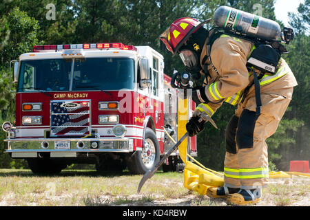 Lt. Trey Thompson, mccrady Feuerwehr, zieht seine Ausrüstung vor Richtung das Flugzeug auf simulierten Unfall während eines abgestürzten Flugzeugs training Juni 30, 2014, mccrady Training Center zu prüfen. während der Übung, militärischen und zivilen Behörden arbeiteten gemeinsam an einer simulierten zu reagieren UH-60 Black Hawk Helikopter kippte. Sie wurden mit einer Vielzahl von Verletzungen durch einfache Schnitte und Kratzer zu schweren Verletzungen und sogar Todesfällen, die entstehen würden, wenn diese ein reales Szenario konfrontiert wurden. Der Zweck der Übung war, Richtlinien, Verfahren, Ausrüstung und Personal zu evaluieren und bereitstellen Stockfoto