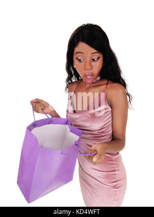 Ein schockiert junge afrikanische Frau in den Leeren Beutel in ein rosa Kleid suchen, auf weißem Hintergrund Stockfoto