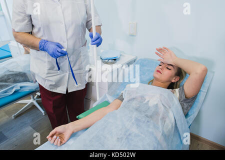 Professionelle Krankenschwester eine Injektion in eine liegende Frau auf OP-Tisch im Krankenhaus Vorbereitung Narkose medizinischen Chirurgie Konzept. Stockfoto