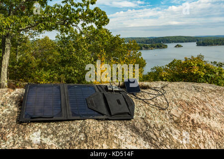 Solarmodul Aufladen eines Mobiltelefons an einem entfernten Standort Stockfoto