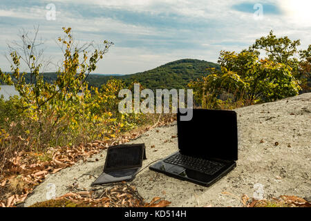 Solarmodul Aufladen einen Laptop an einem entfernten Standort. Stockfoto