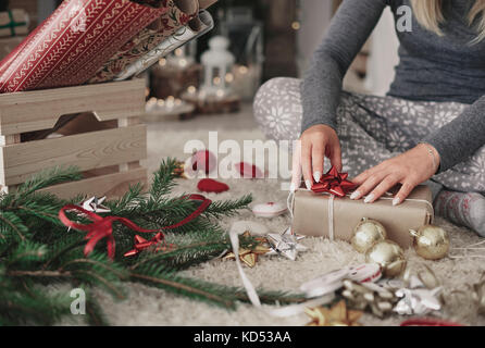 Menschliche Hand dekorieren ein Weihnachtsgeschenk Stockfoto