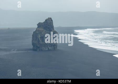 Felsbrocken auf schwarzen vulkanischen Strand am Kap dyrholaey im südlichen Island bei Nebel Stockfoto