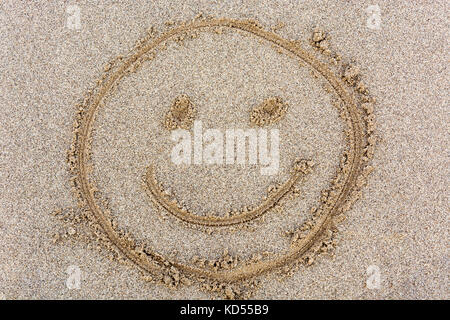 Ein smiley Gesicht im Sand von oben gezeichnet Stockfoto