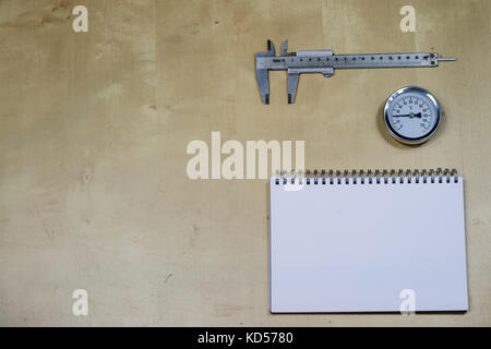 Materialien, Zubehör und Ersatzteile für Hydraulik. Noten- und Messwerkzeuge auf dem Workshop Tabelle. Holztisch. Stockfoto