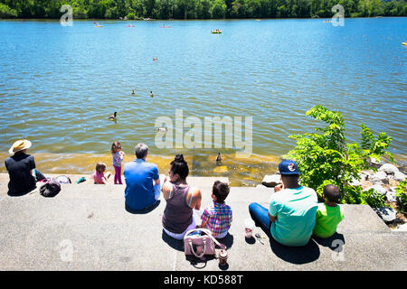 Washington DC - Mai 24, 2015: Die Menschen an der Georgetown Waterfront Park sitzen auf der Treppe entlang des Potomac die Sonne genießen. Familien mit Kind Stockfoto