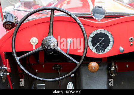 Kutna Hora, Tschechische Republik - 18. August 2017: Nahaufnahme eines roten Armaturenbretts mit Tachometer und Lenkrad eines Oldtimers, der in der Altstadt geparkt ist Stockfoto