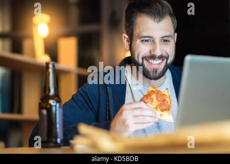 Entspannt männliche Person essen Pizza Stockfoto