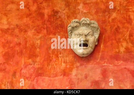 Stein der verärgerten Mann gegen ein helles Orange Wand. Antike römische Kopf in Museum glyptotek in Kopenhagen, Dänemark. Stockfoto