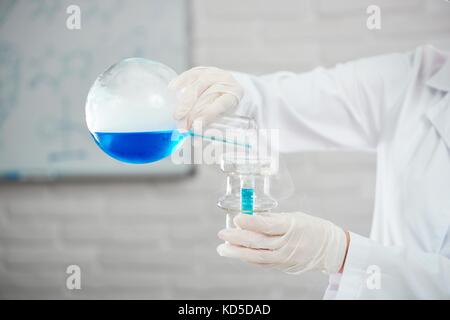 Zugeschnittener Schuss eines Wissenschaftlers in Uniform, der eine Forschung am Chemikalienraboratorium durchführt. Stockfoto