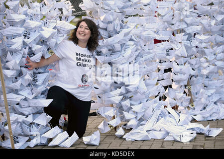 Die Sekretärin des GMB Schottland Rhea Wolfson posiert mit 2,000 Papierbooten, die aus Kopien des SNP-Manifests hergestellt wurden, während die Gewerkschaft einen öffentlichen Appell im Namen von 2,000 Gleichzahlern einleitet und den Stadtrat von Glasgow auffordert, Verhandlungen in Gang zu bringen So bald wie möglich, Bei der Konferenz der Scottish National Party im SEC Center in Glasgow. Stockfoto