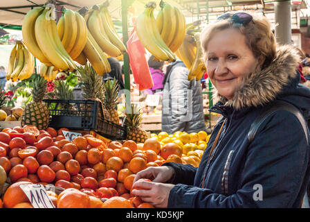 Schöne blonde Frau mittleren Alters, kauft Lebensmittel auf dem Markt, Obst und Gemüse Stockfoto