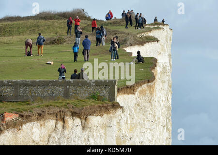 Touristen in der Nähe der Kante der Bröckelnden Kreidefelsen am Birlng Lücke, East Sussex Stockfoto