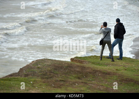 Touristen in der Nähe der Kante der Bröckelnden Kreidefelsen am Birlng Lücke, East Sussex Stockfoto