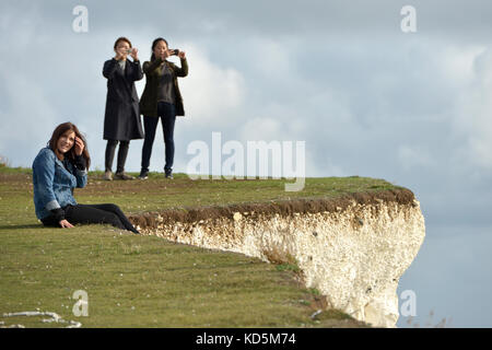 Touristen in der Nähe der Kante der Bröckelnden Kreidefelsen am Birlng Lücke, East Sussex Stockfoto