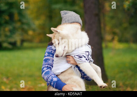 Die Beziehung zwischen dem Eigentümer und dem Hund. Frau hält den Husky. Stockfoto