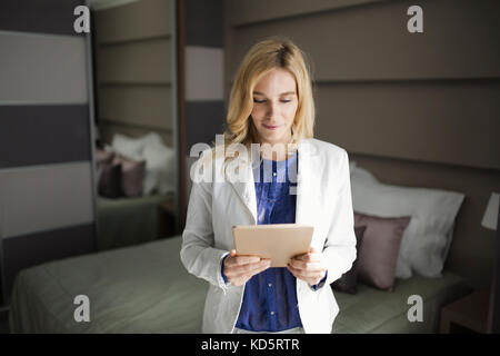 Portrait der Unternehmerin mit Tablet-PC im Hotel Zimmer Stockfoto