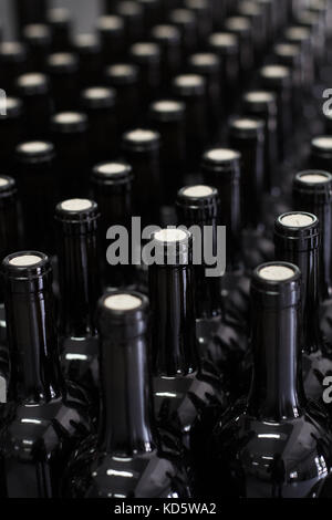 Die vertikale Perspektive Nahaufnahme von korkgeschmack Rotwein Flaschen in den Zeilen auf der Produktionslinie im Weingut Stockfoto