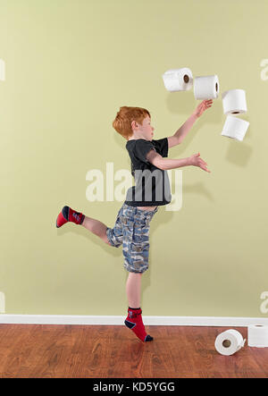 Junge 4-7 Werfen Rollen von Toilettenpapier Stockfoto
