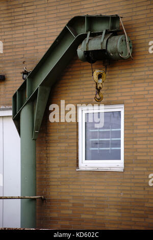 Ein alter Kran an der Seite einer Station Gebäude für das Verladen der Güter. Stockfoto