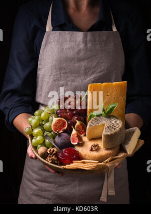 Frau mit einem Käseplatte mit Früchten und Marmelade Stockfoto