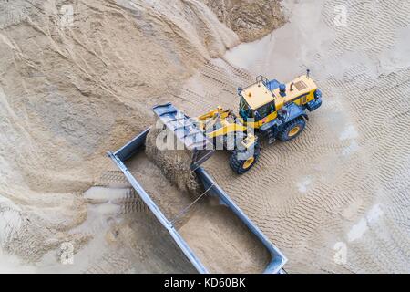Gelber Radlader laden Sand auf Kipper. sand Steinbruch Stockfoto