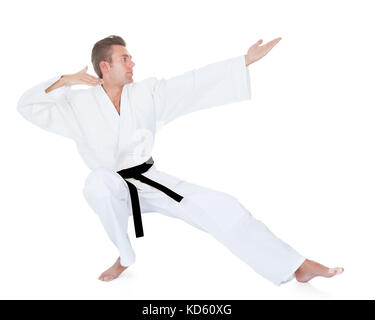 Junger Mann im Kimono üben Karate Over White Background Stockfoto