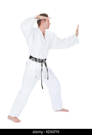 Junger Mann im Kimono üben Karate Over White Background Stockfoto