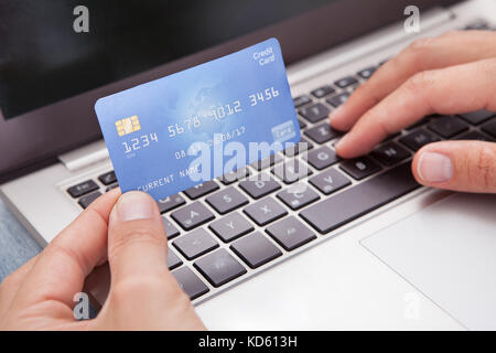 Junger Mann mit Laptop und Kreditkarte, Online-Shopping Stockfoto