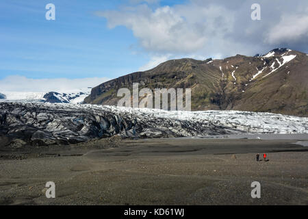 Felsiger Pfad zum Skaftafellsjokull Gletscher mit wenigen unerkennbaren Menschen, im Sommer in Skaftafell, Island Stockfoto
