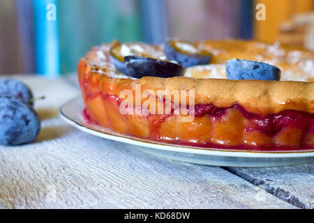 Pflaumenkuchen oder Torte und Pflaumen auf rustikalen Hintergrund Stockfoto