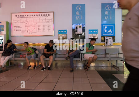 Chinesen, Touristen, Reisende mit Telefone am Liangjiang Flughafen Guilin, China, Asien Stockfoto