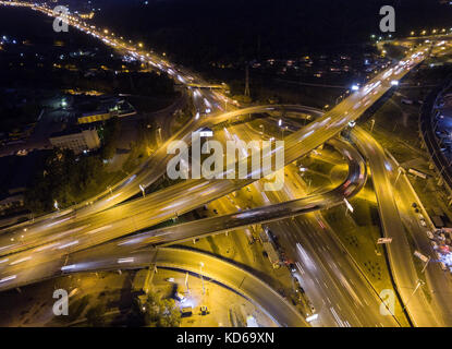Vertikal von oben nach unten Luftbild von Verkehr auf autobahnanschlussstelle bei Nacht. Stockfoto
