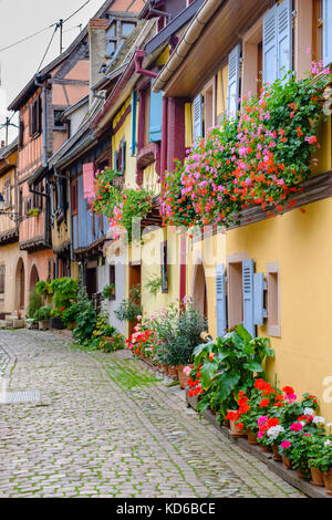 Eine kleine Straße führt durch die Blume dekoriert Fachwerkhäuser der historischen Dorf Stockfoto