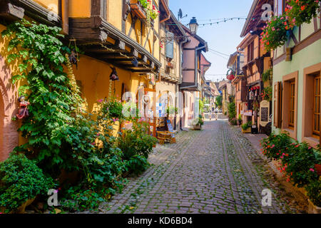 Eine kleine Straße führt durch die Blume dekoriert Fachwerkhäuser der historischen Dorf Stockfoto