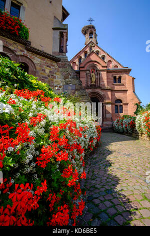 Eine kleine, mit Blumen dekoriert Straße führt zu einer kleinen Kirche im historischen Dorf Stockfoto