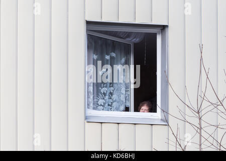 Alte Frau in ihrer Wohnung verstecken und Beobachten ausserhalb leben Stockfoto