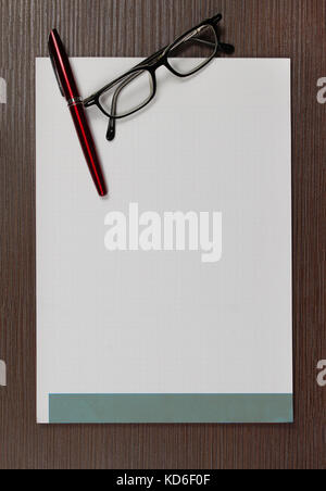 Weiße leere notepad Seite mit Brille und Stift in der Ecke der Tabelle Stockfoto