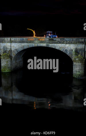 1988 Ford 7610, tritt zwei Traktor und New Holland 525 Feldhäcksler auf einer Brücke bei Nacht wiederhergestellt Stockfoto