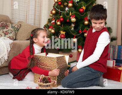 Kind in Santa hat Spaß und Spielen, Geschenke, Weihnachten Dekoration zu Hause, glücklich, Emotion, Winterurlaub Konzept Stockfoto