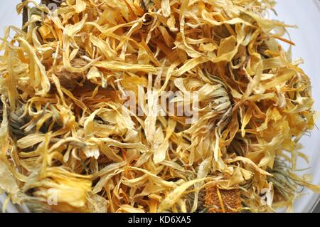 Getrocknete Ringelblumen (Calendula officinalis) Blütenblätter, Heilpflanze in eine Glasschüssel, Ansicht von oben, isoliert auf Weiss. Stockfoto