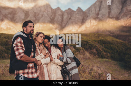 Freunde auf Urlaub in einer Landschaft suchen. Gruppe von Mann und Frau zusammen auf Roadtrip ständigen bewundernden Blick in die Landschaft. Stockfoto