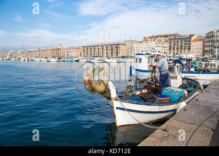 Fischer ziehen die Fische aus dem Netz in Vieux Port (alter Hafen) am Markttag, Marseille, Frankreich Stockfoto