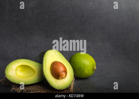 Avocado und Kalk auf steinernen Tisch Stockfoto