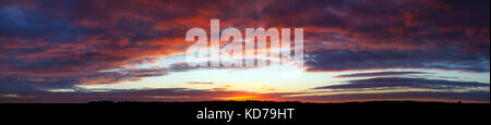 Wunderschöne Landschaft Panorama mit blauem Himmel, Wolken und Sonnenuntergang. Panoramablick auf den Sonnenaufgang, ein neuer Tag. Sonnenstrahlen durch die Wolken leuchten Stockfoto