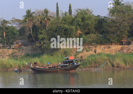 Arbeitnehmer entlasten Bündel Stroh aus einem Riverboat eine zakagyi Dorf auf dem Irrawaddy Fluss günstig in Myanmar (Burma). Stockfoto