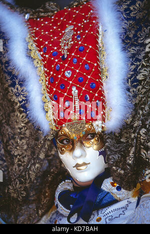 Italien. Venedig. Karneval. Frau in Kostüm. Nahaufnahme des Gesichts mit Gold- und weißer Maske.