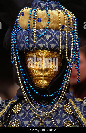 Italien. Venedig. Karneval. Frau in Kostüm. Nahaufnahme des Gesichts mit Gold und Maske.