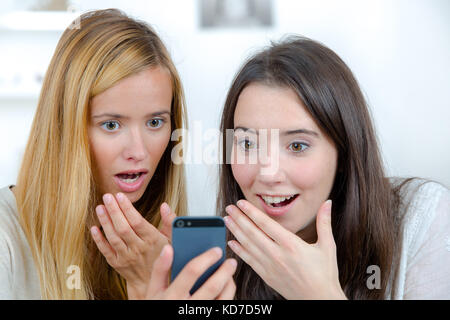 Euphorisch Freunde Ansehen von Videos auf einem Smartphone Stockfoto