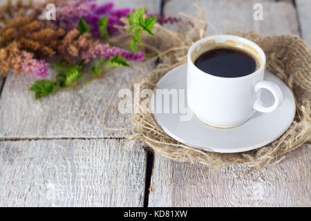 Kaffeebecher mit Blumen guten Morgen auf weißem rustikalen Tisch Stockfoto